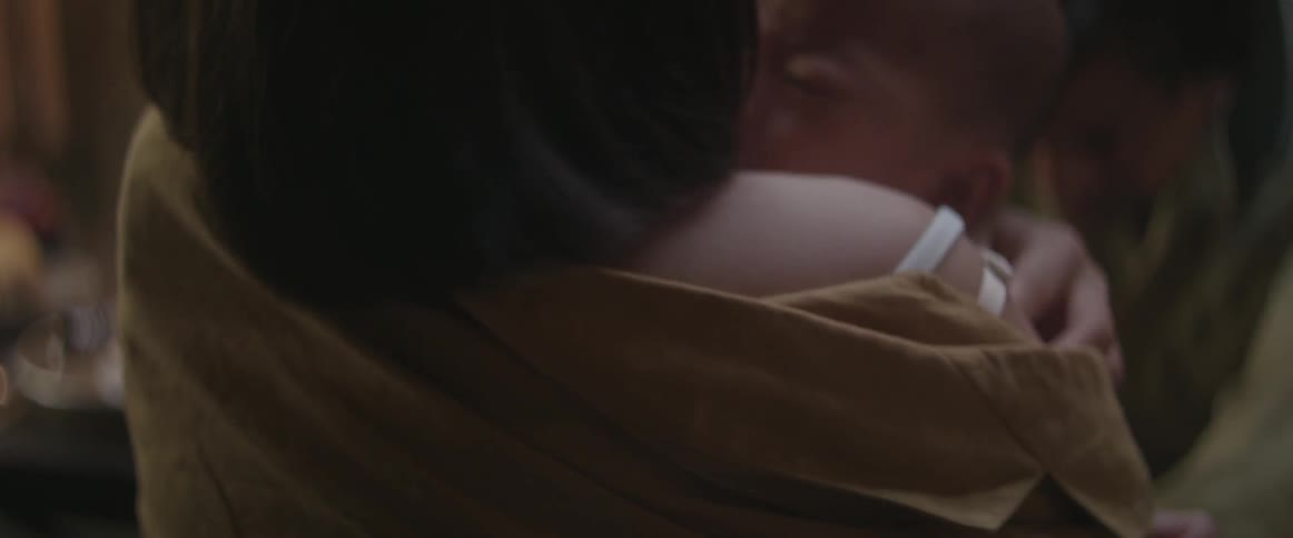 A close up view of  a woman's back as she is struggling with someone