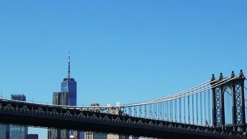 A city stretches behind a bridge
