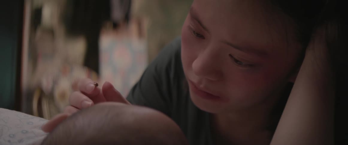 A woman rubs the head of a baby