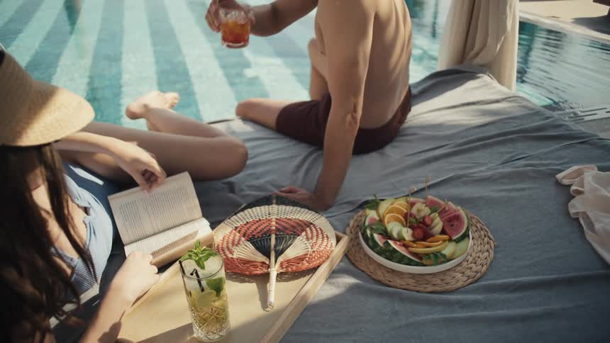 Couple lounging by poolside cabana