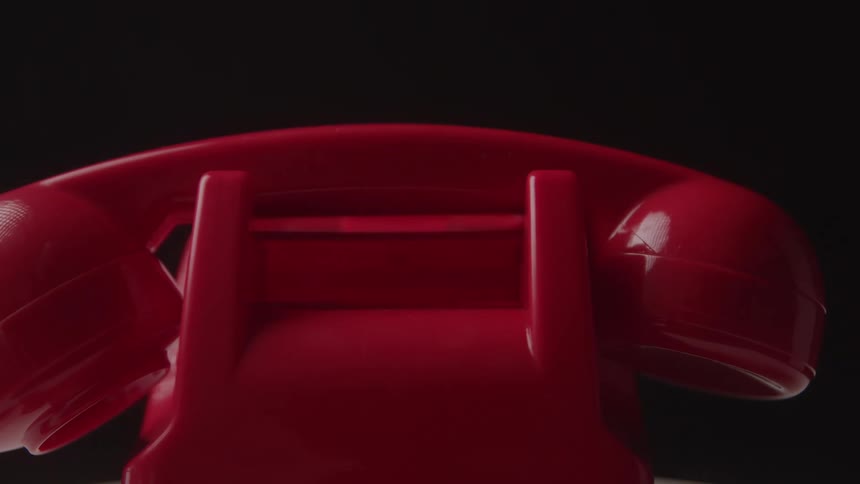 A bright red retro rotary phone shows the handset being lifted from its cradle ready to be used