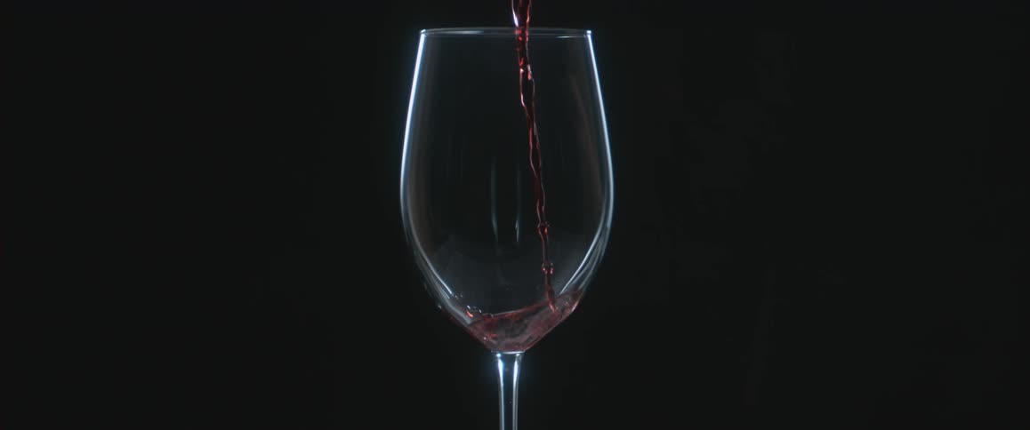 Red wine is poured into a glass