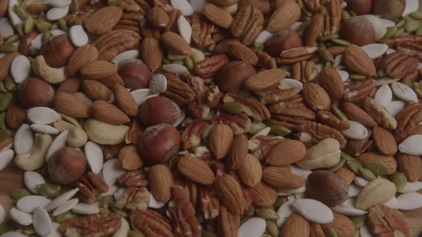 Mixture of nuts and seeds both shelled and in their shells cover an area