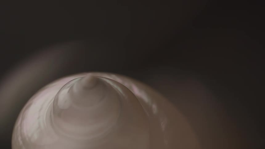 A closeup shot of a piece of clay spinning on a potters wheel the clay is being shaped into a point indicating the beginning stages of creating a vessel