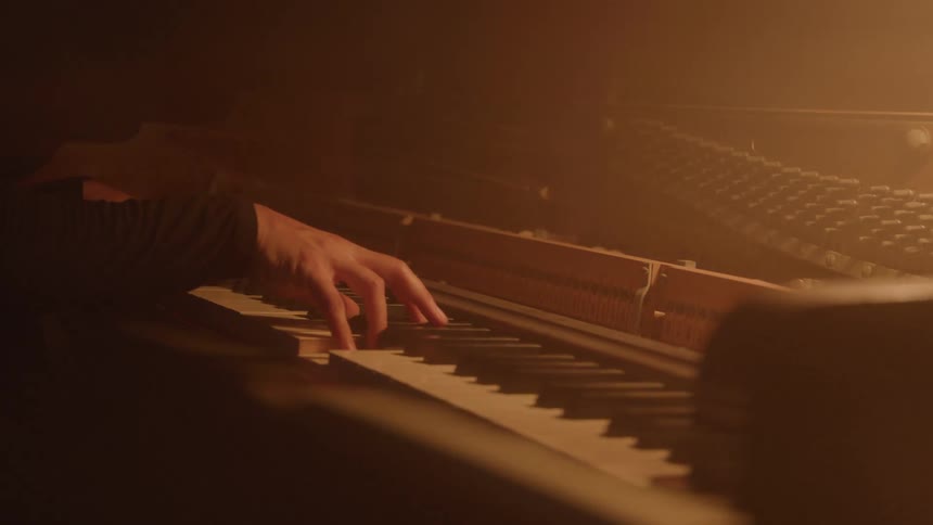 A mans hands playing the piano