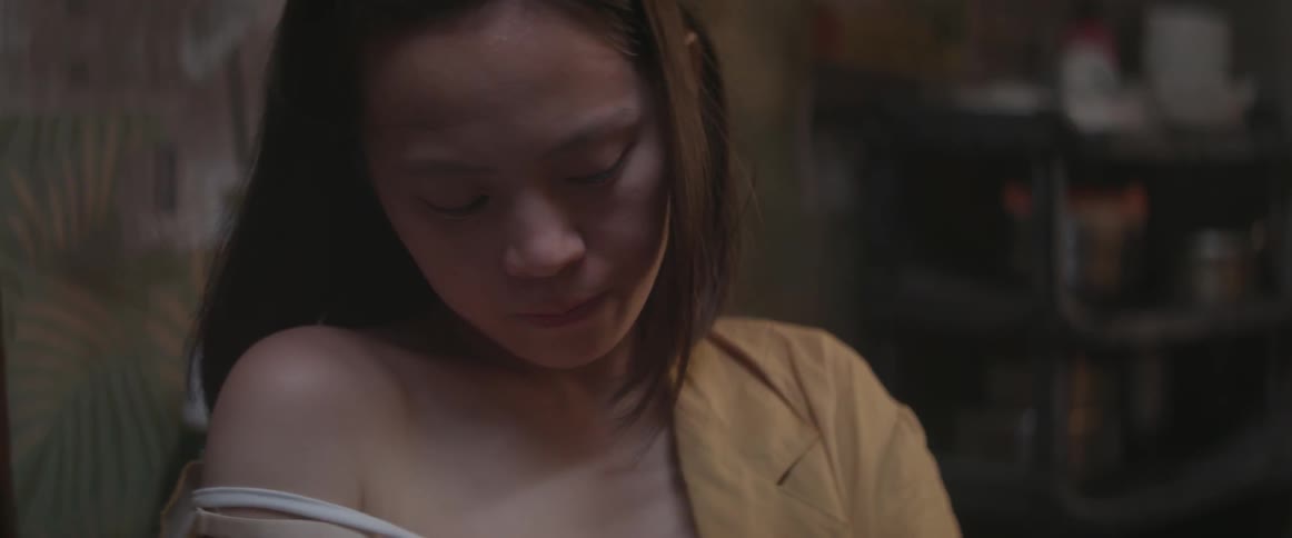 A woman with an open shirt looks down at her lap