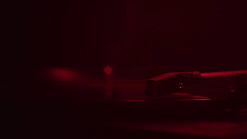 The video shows a dark red background with some subtle circular patterns a small dark shape appears and quickly disappears