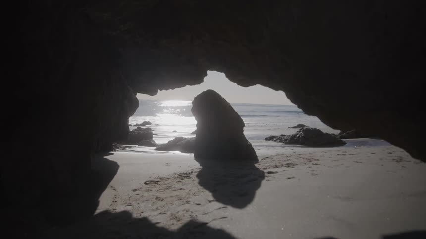 Rocky cave in the sand of the beach
