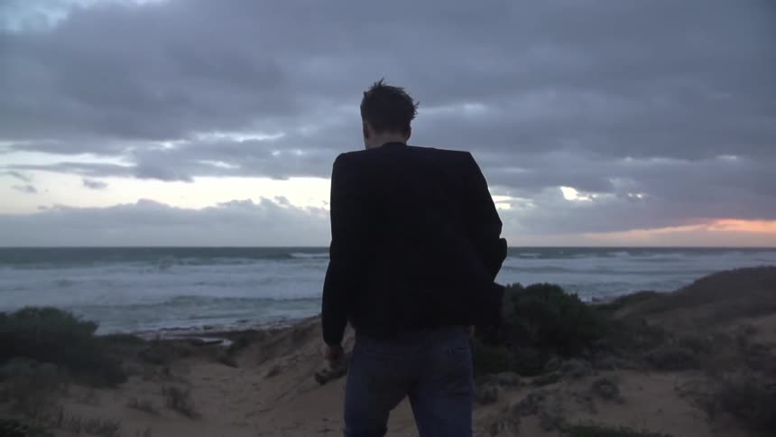 Man walking towards the water on the beach
