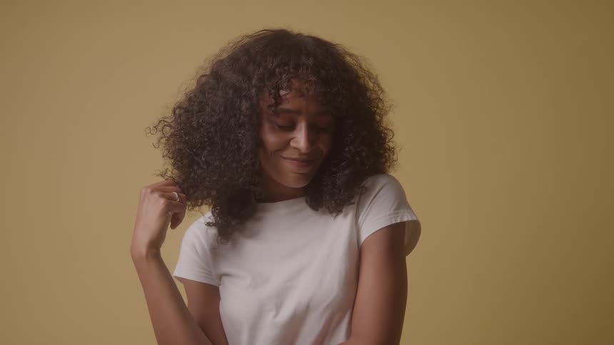 The woman swirls her curly hair