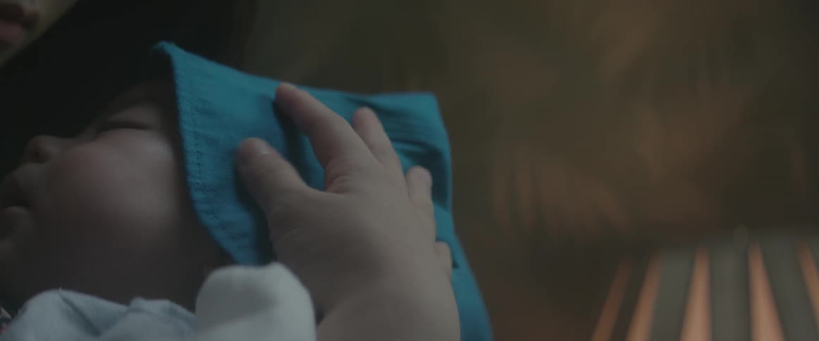 A woman holding a baby and rubbing its head