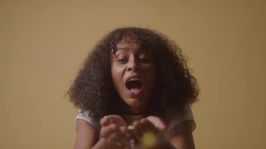 Woman blowing on the glitter in her hands