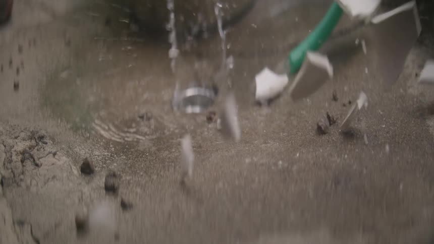 Pottery shatters as it falls into a basin