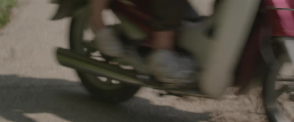 A couple of people riding on a motorcycle and it only shows from their shins down