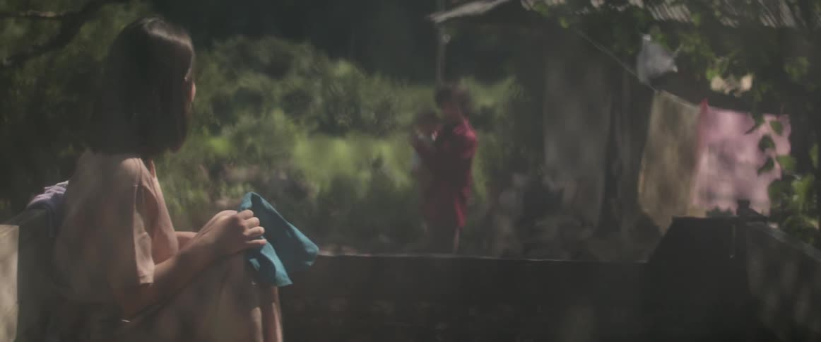 A woman clutches a piece of fabric as a truck drives off