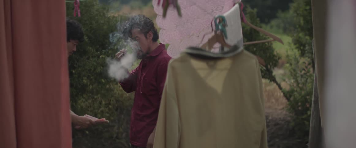 A man that is smoking is handed money