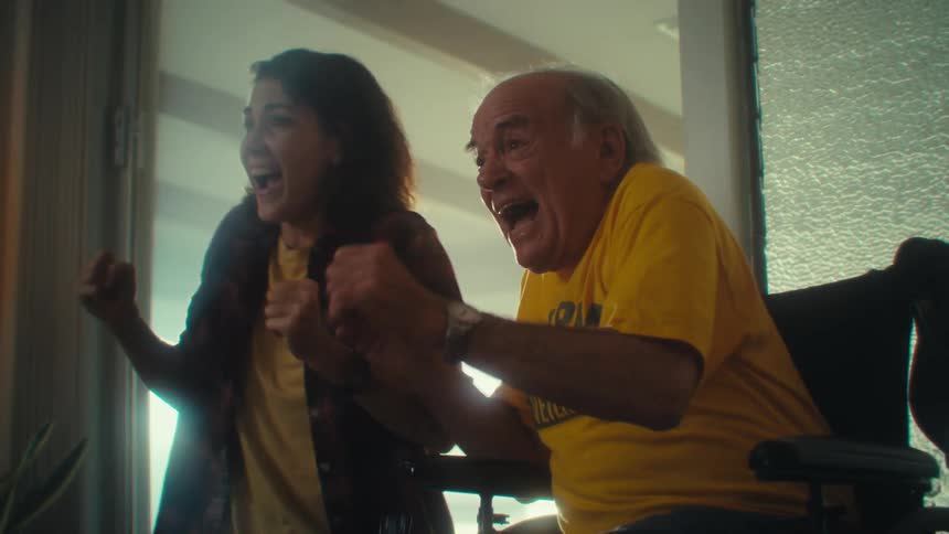 Elderly man and woman hugging at a celebration in the living room