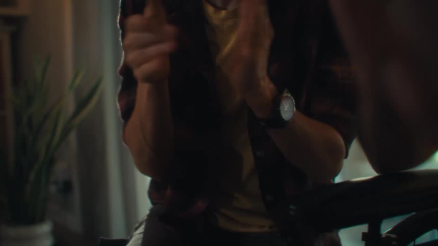 Man in a yellow shirt smiling while a woman in the background claps