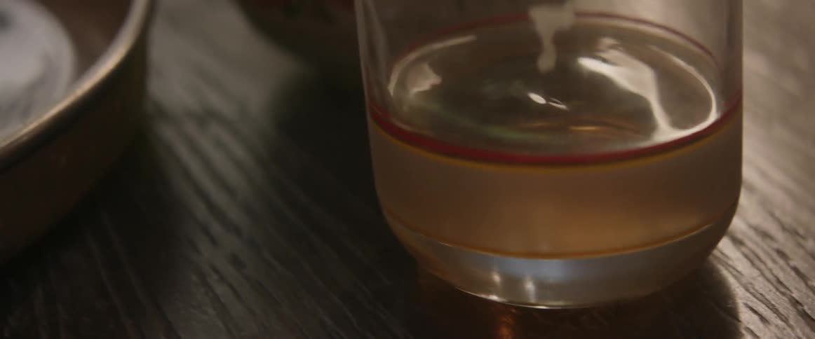 A glass of liquid is vibrating on a table