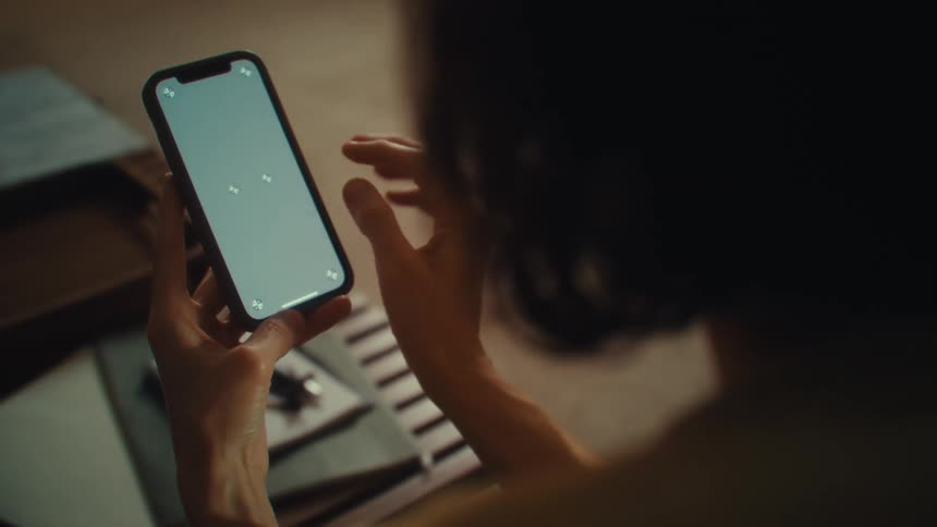 A woman looks at a phone screen