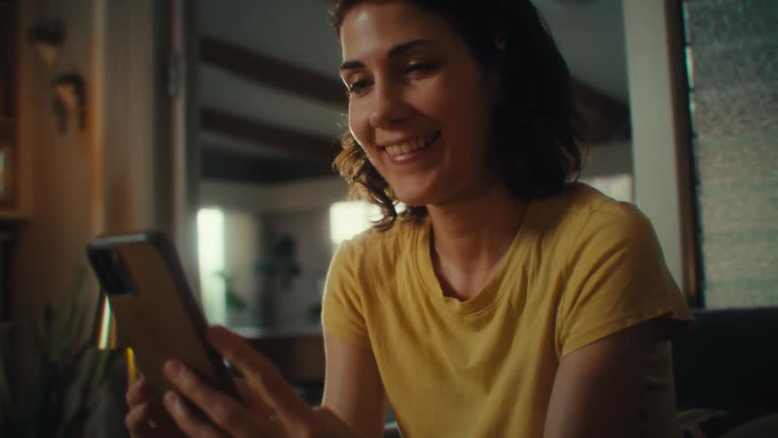 Woman facetiming on cell phone in her living room