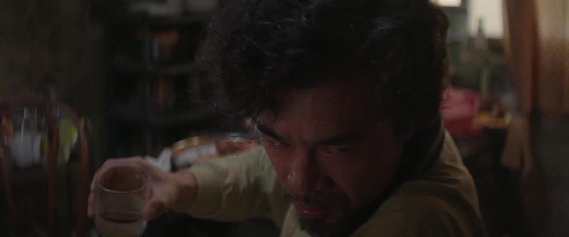 A man turns and drinks from a glass