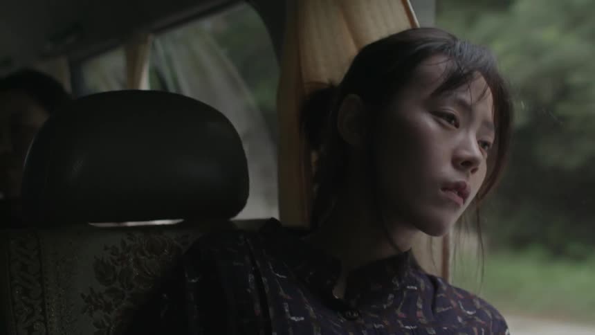 An asian woman rides in the passenger seat of a van