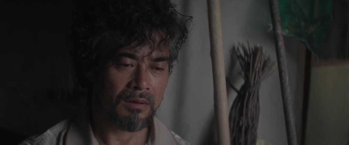 A disheveled asian man looks around