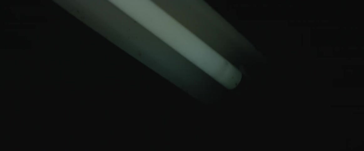 A shop light flickers in a dark room