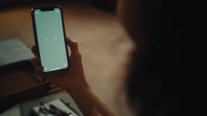 A woman looks at a phone screen