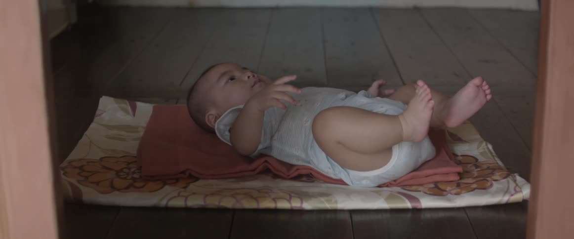 An infant lays on blankets