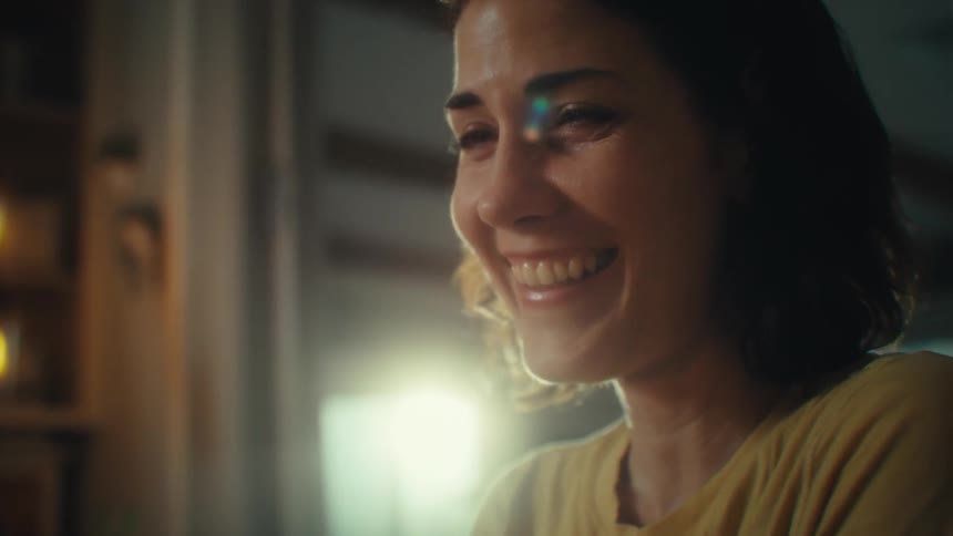 Smiling woman sitting interacting with a smartphone