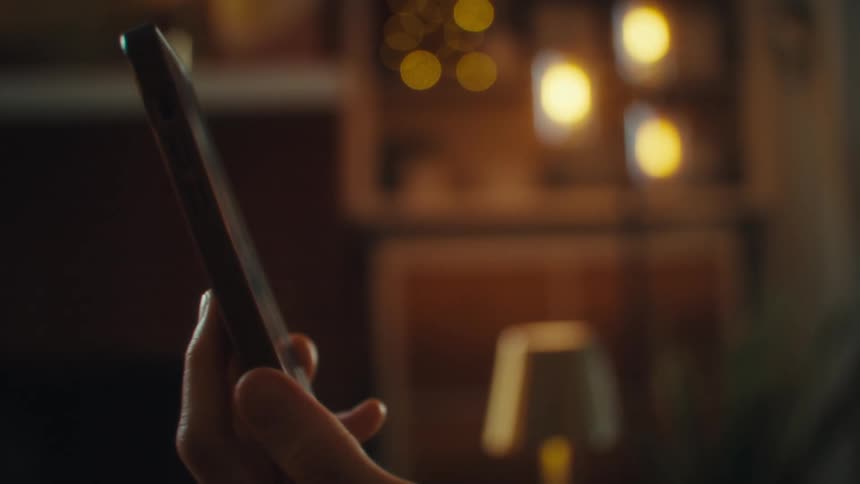 Person holding up a cell phone in a living room