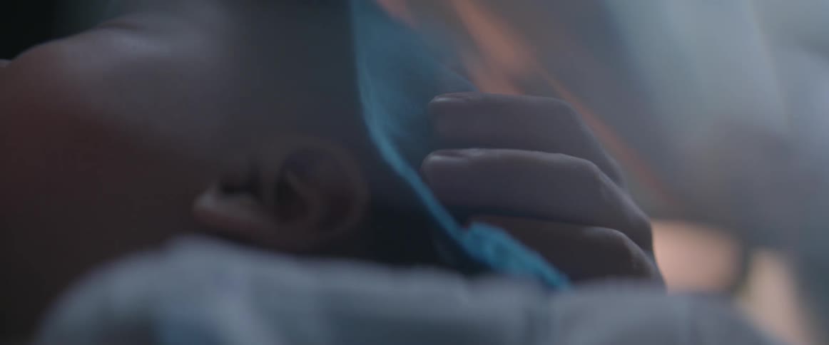 A blanket wrapped baby is being held