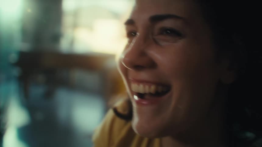 Woman smiles while energetically playing a video game at home during the daytime