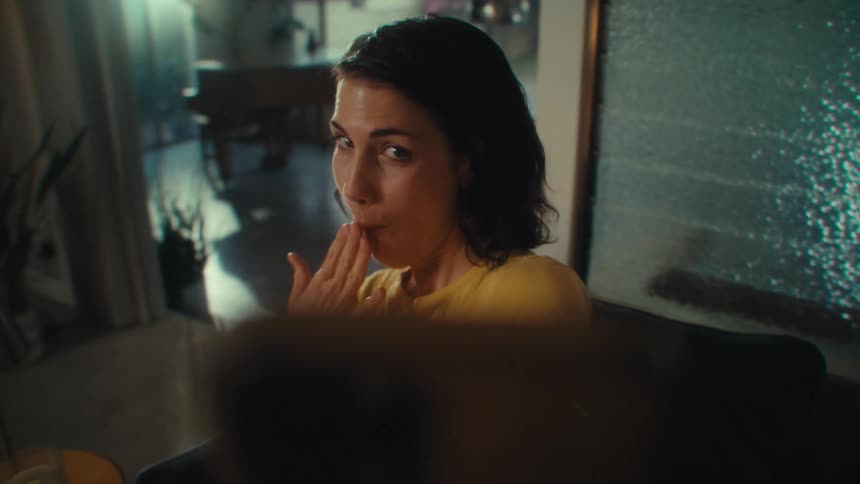 Woman looking at her cell phone with a curious expression and her hand raised