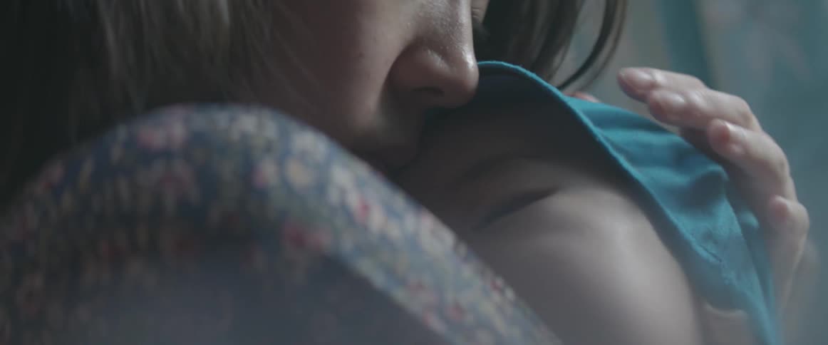 A woman holds a baby to her chest