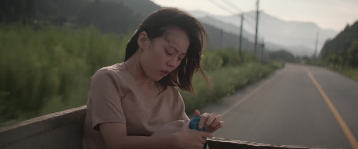 A woman is sitting in the back of a pick up truck