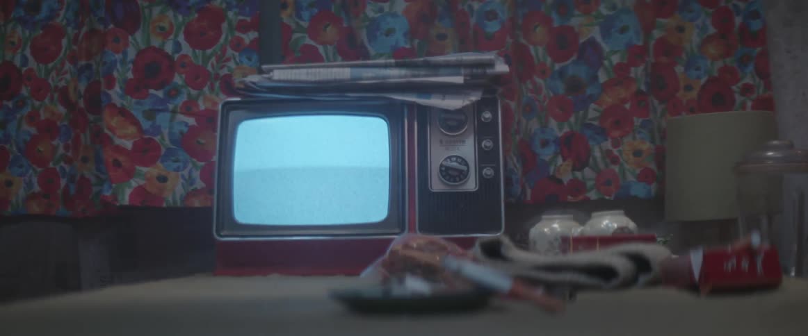 A small tv sits with a blank screen on a table in a room
