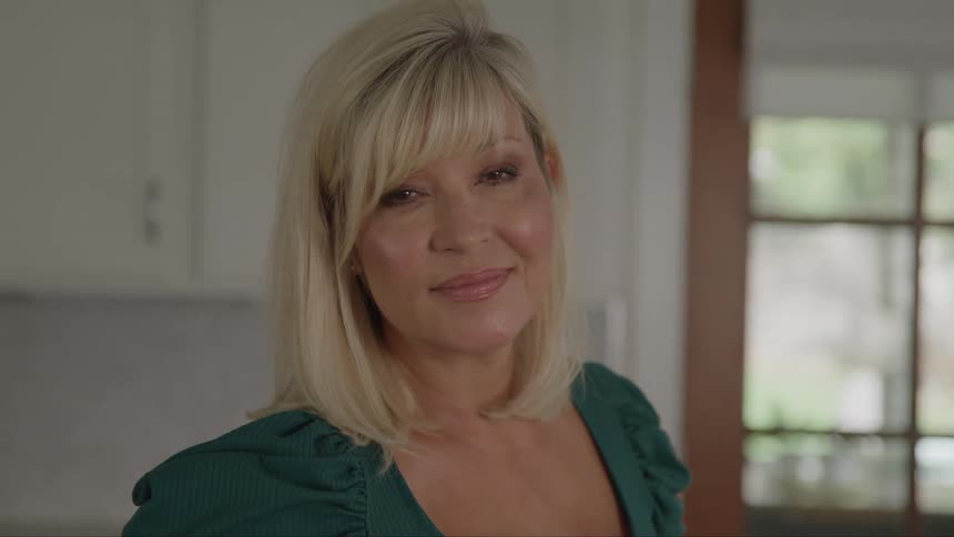 A woman smiles at the camera