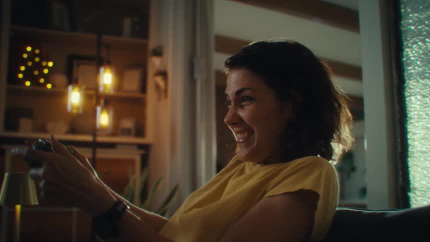 Woman smiling while playing video games with a controller in her hands
