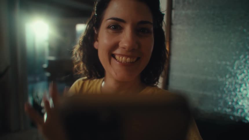 Point of view woman waving hello as she exitedly face times on her cell phone