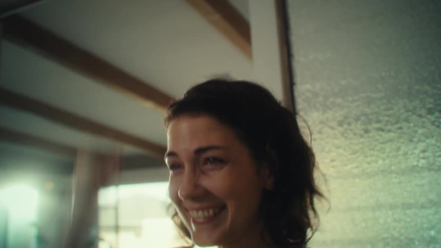 Close up of a young woman gaming with a controller and celebrating a win while sitting in a living room during daytime