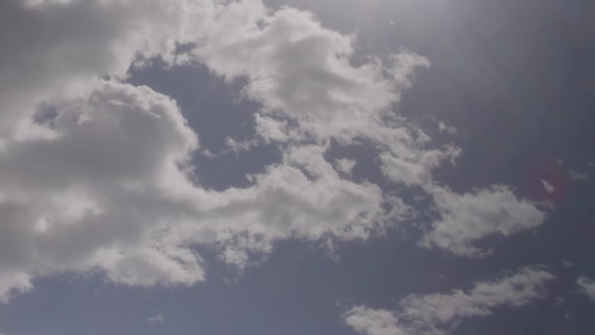 White fluffy clouds rolling across blue skies