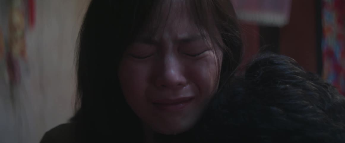 A woman is sobbing in a dark area
