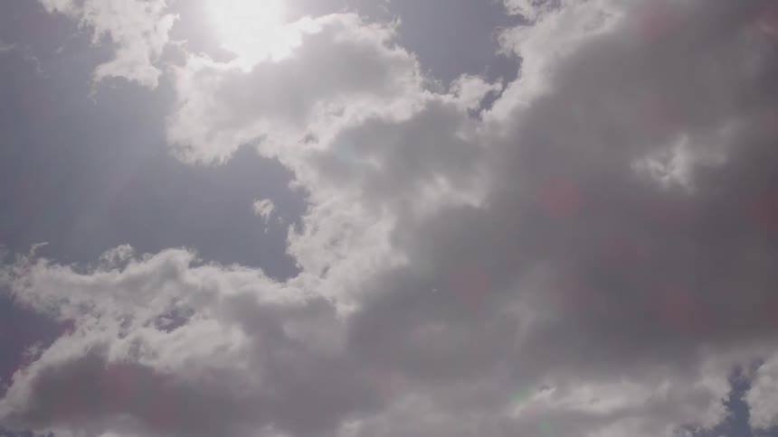 Dark clouds slowly cover the sky on a sunny day