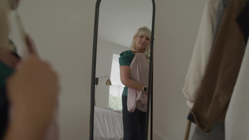 A woman is modeling clothing in the mirror