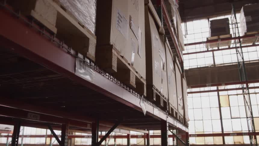 The inside of a warehouse shows several large boxes stacked on shelves