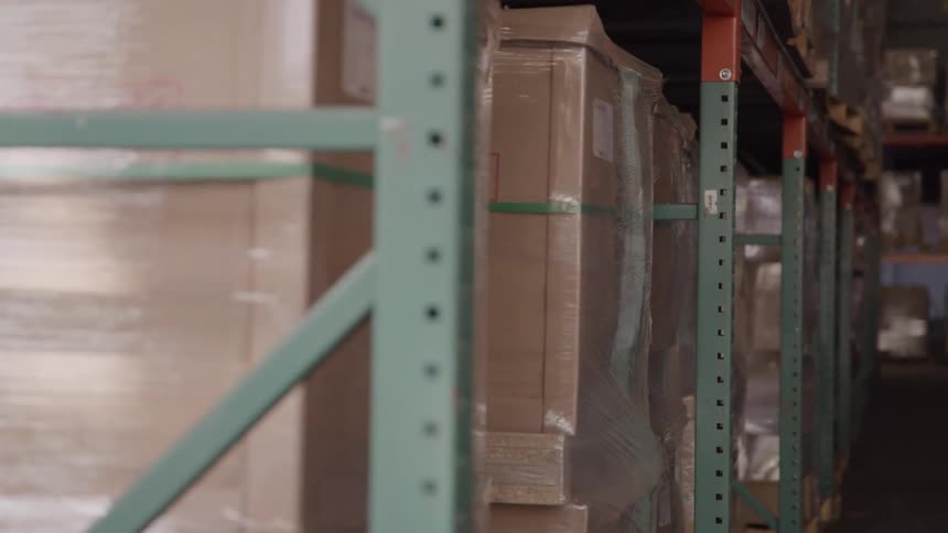 Pallets and boxes line the walls of a warehouse