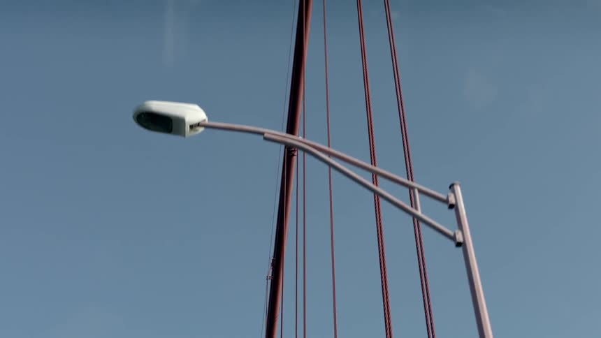Suspension cables on a bridge stand out against a blue sky